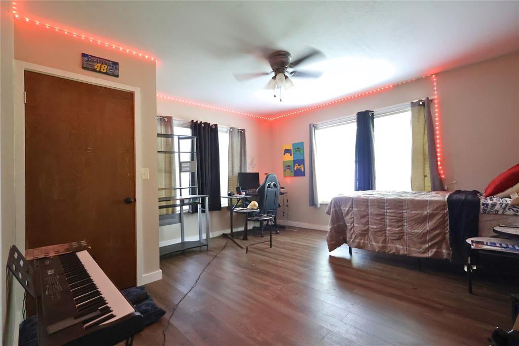 210 Hopkins Street Alba, TX 75410 - Photo 29 of 36 Bedroom featuring multiple windows, an office area, wood finished floors, and a ceiling fan