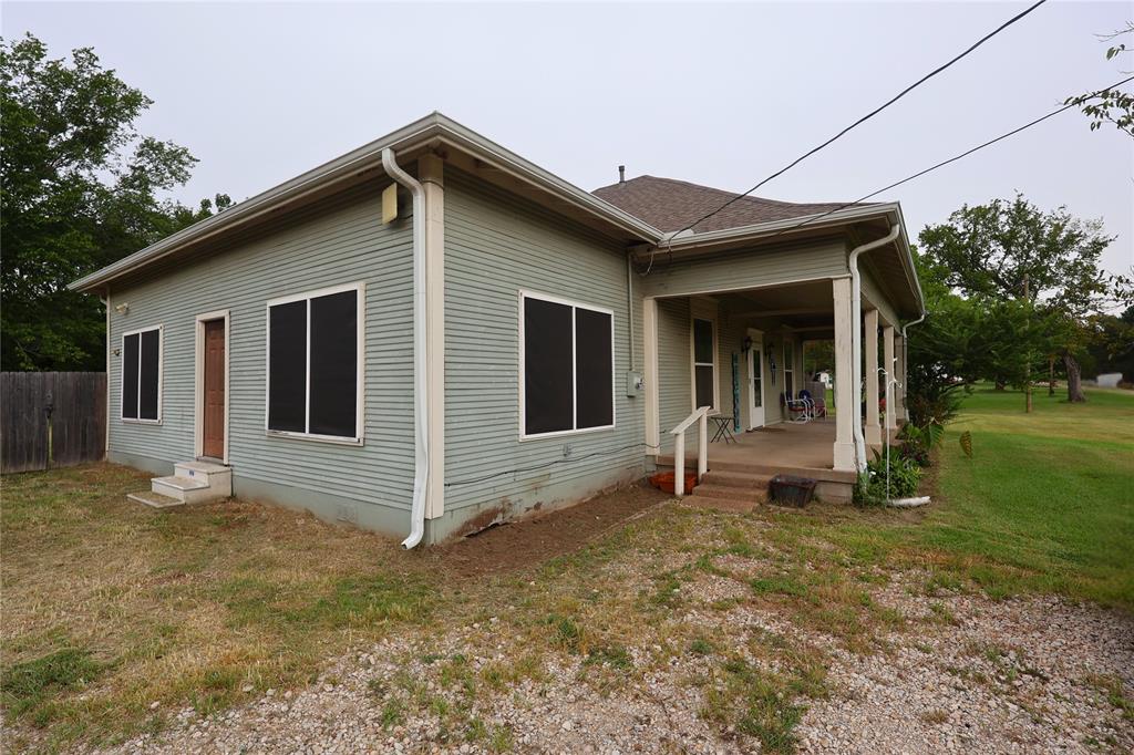 210 Hopkins Street Alba, TX 75410 - Photo 33 of 36 View of home's exterior featuring a yard and roof with shingles