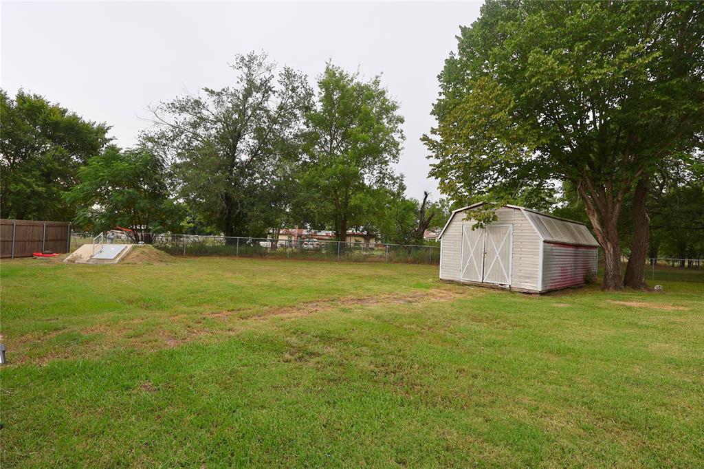 210 Hopkins Street Alba, TX 75410 - Photo 34 of 36 View of yard with a shed and view of wooded area