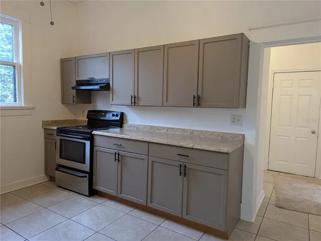 a kitchen with cabinets appliances and a window