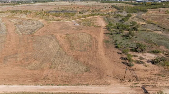 a view of a dry yard with wooden fence
