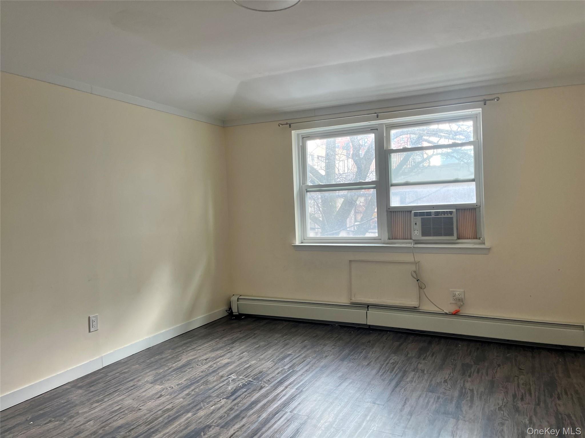 142-01 37th Avenue, Unit 3F Queens, NY 11354 - Photo 4 of 5 a view of an empty room with wooden floor and a window