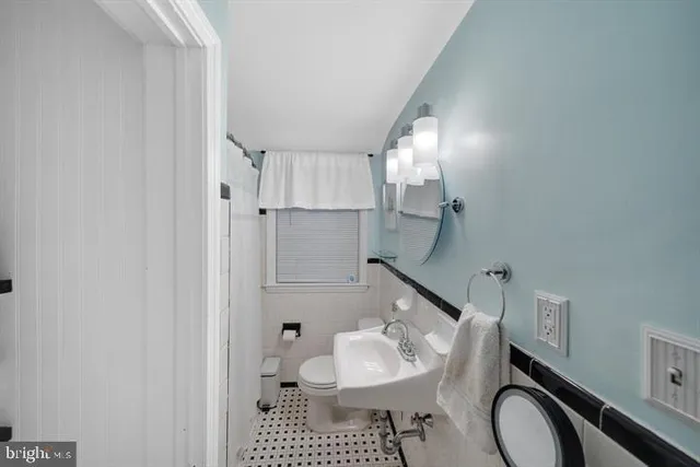 a bathroom with a sink toilet and a mirror