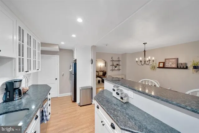 a large kitchen with granite countertop a sink and a refrigerator