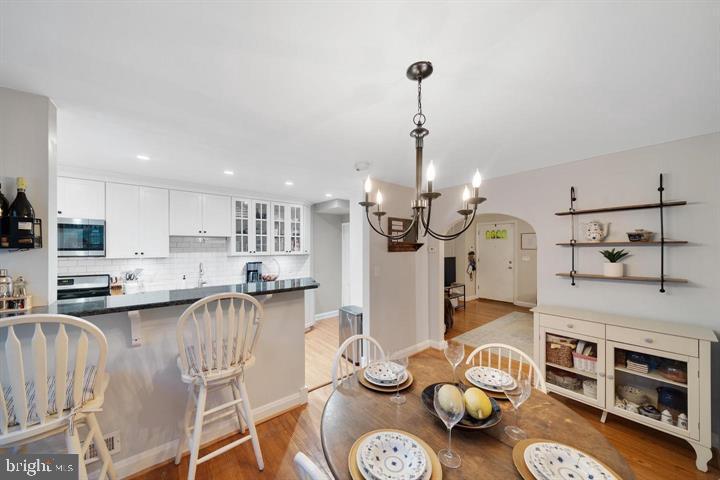 1660 Aberdeen Road Towson, MD 21286 - Photo 9 of 28 a open kitchen with stainless steel appliances granite countertop a stove a sink a dining table and chairs with wooden floor