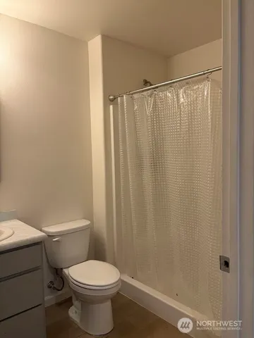 a white toilet sitting next to a shower