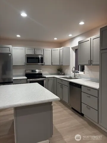 a kitchen with a sink a microwave and cabinets