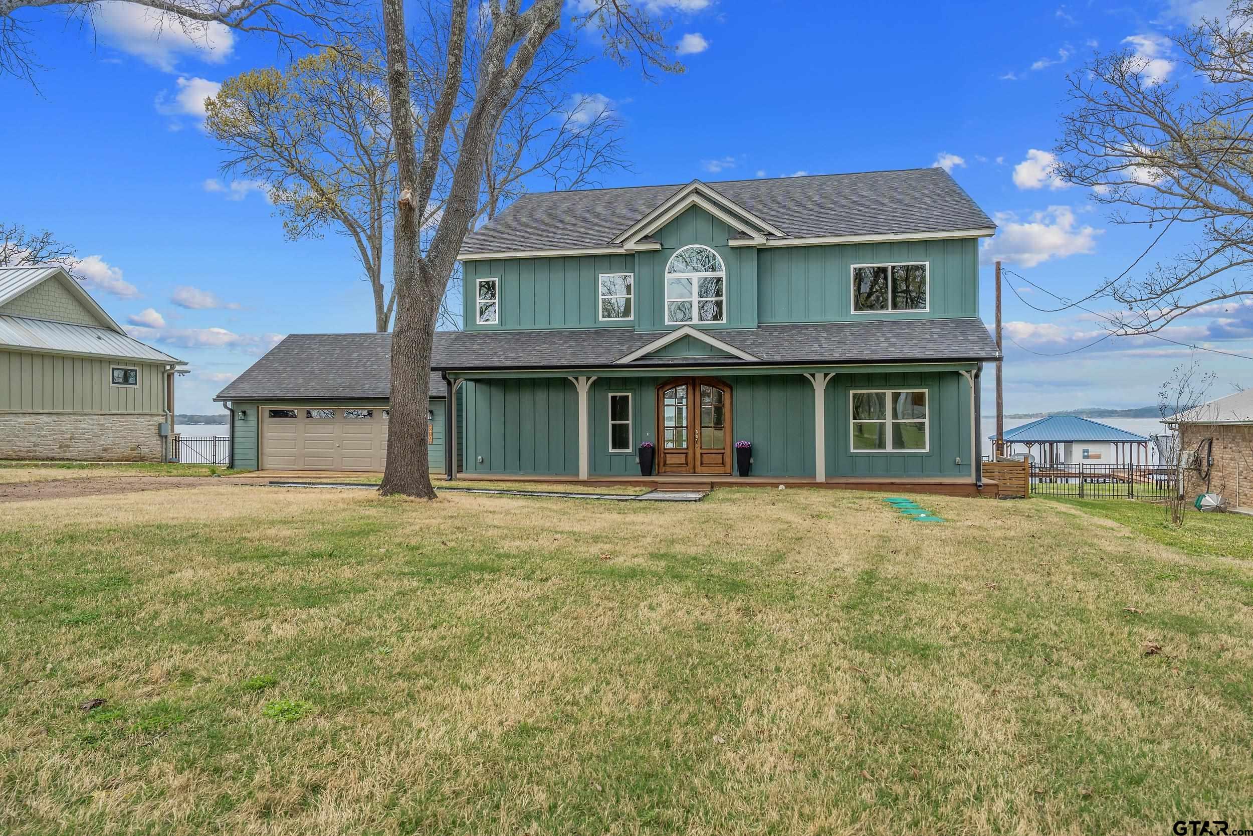 a front view of a house with a garden and trees