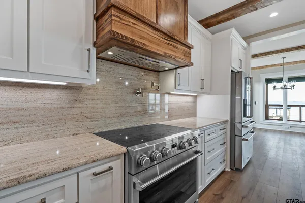 a view of an empty room with wooden floor and cabinets