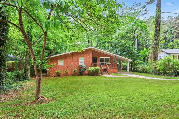a front view of a house with a yard and trees