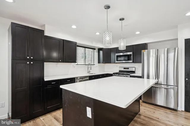 a kitchen with stainless steel appliances a refrigerator sink and microwave