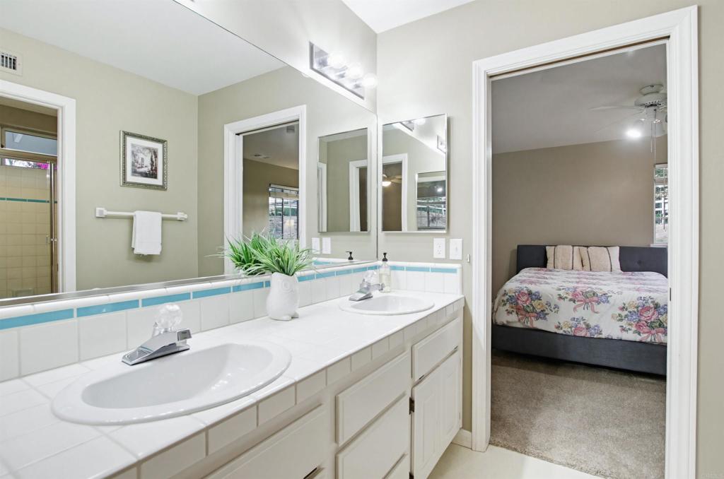 2092 Tudor Lane Fallbrook, CA 92028 - Photo 19 of 52 a en suite bathroom with a double vanity sink and a mirror