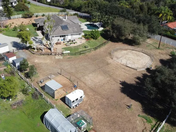 an aerial view of a house with garden space lake view and trees