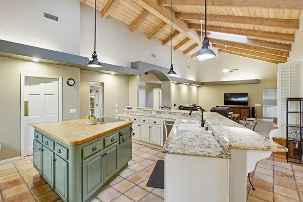 a large kitchen with kitchen island a sink a counter space and stainless steel appliances