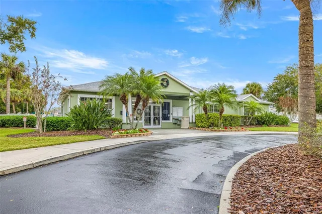 a view of a house with a yard and potted plants