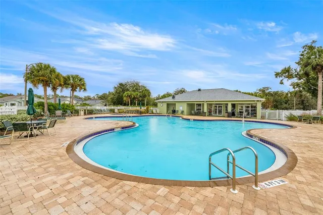 a view of a swimming pool with lawn chairs and couches