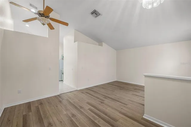 a view of empty room with wooden floor