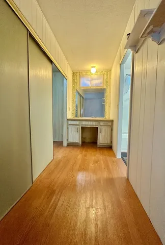 a view of empty room with wooden floor and window