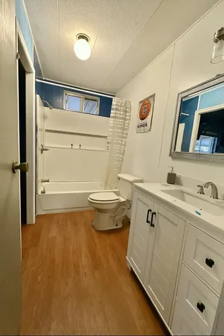 a bathroom with a granite countertop sink toilet and shower