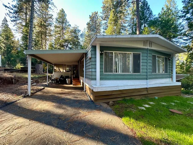 a view of a house with backyard and sitting area