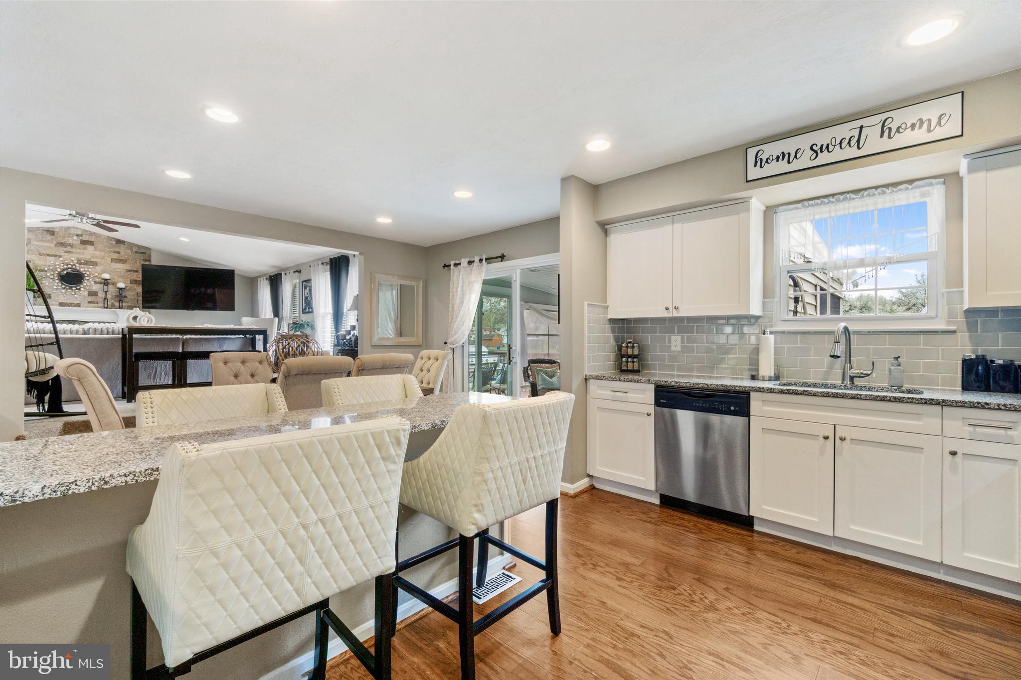 8339 Capel Drive Pasadena, MD 21122 - Photo 11 of 51 a living room with furniture a fireplace and a kitchen view