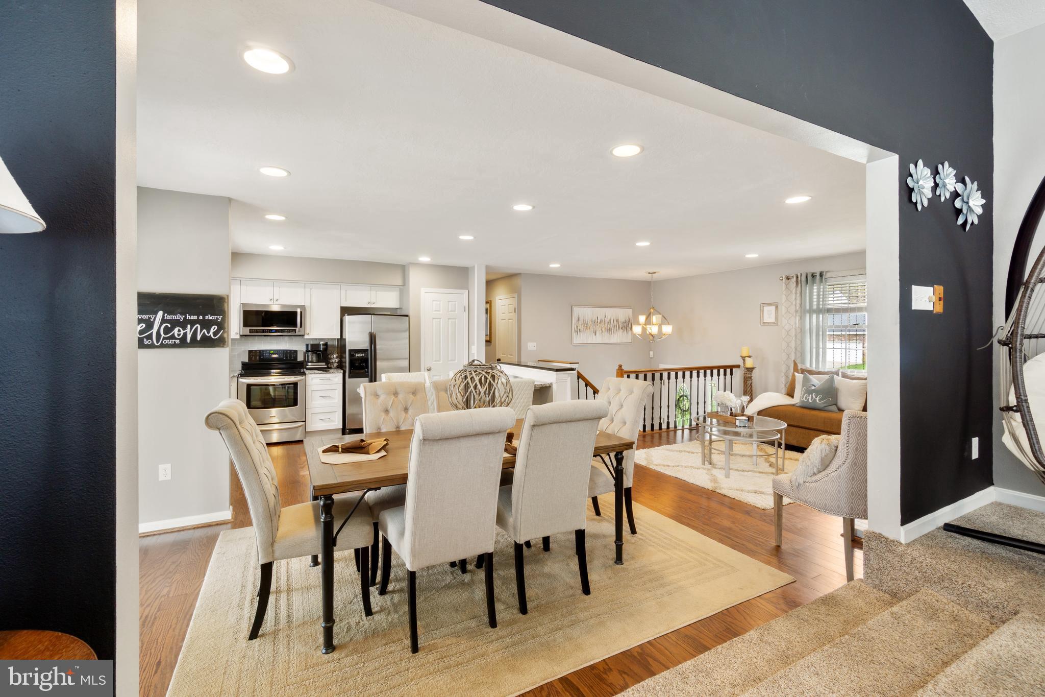 8339 Capel Drive Pasadena, MD 21122 - Photo 14 of 51 a dining room with stainless steel appliances kitchen island granite countertop a dining table chairs and a kitchen view