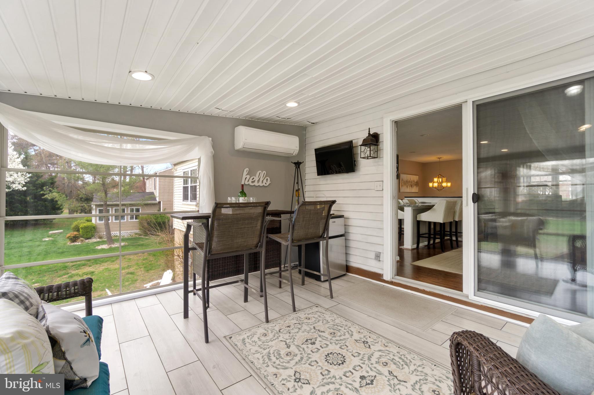 8339 Capel Drive Pasadena, MD 21122 - Photo 24 of 51 a living room with a patio garden view and a floor to ceiling window