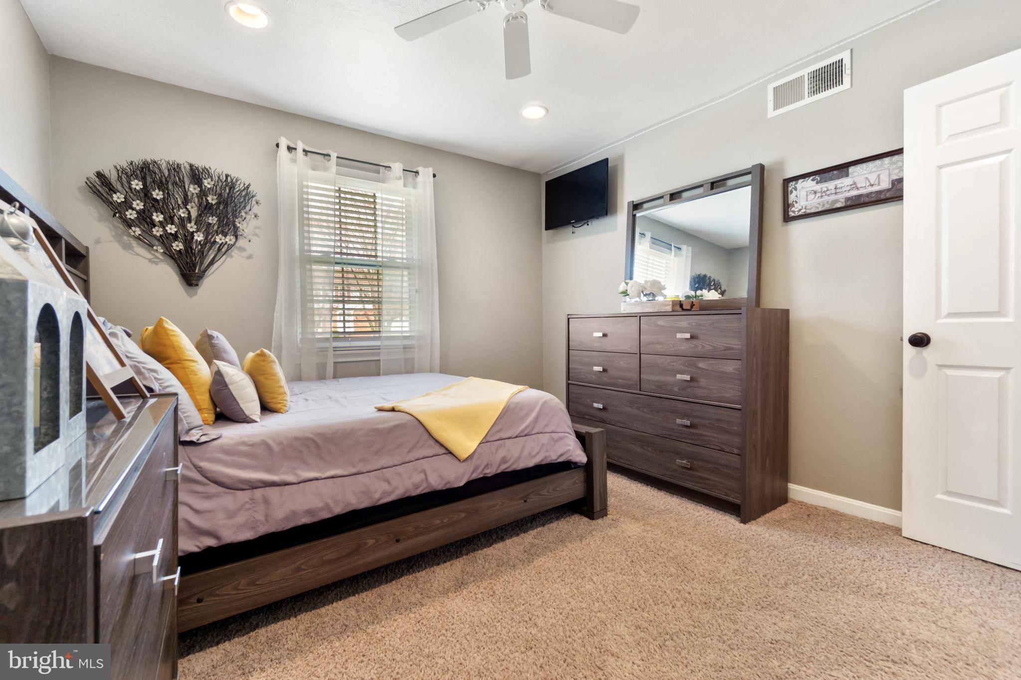 8339 Capel Drive Pasadena, MD 21122 - Photo 32 of 51 a bedroom with a bed dresser and wooden floor