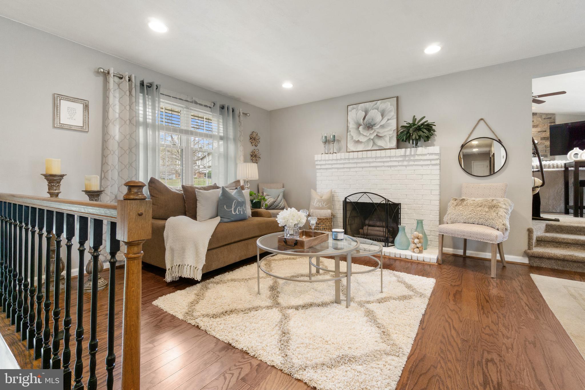8339 Capel Drive Pasadena, MD 21122 - Photo 7 of 51 a living room with furniture a clock and a fireplace