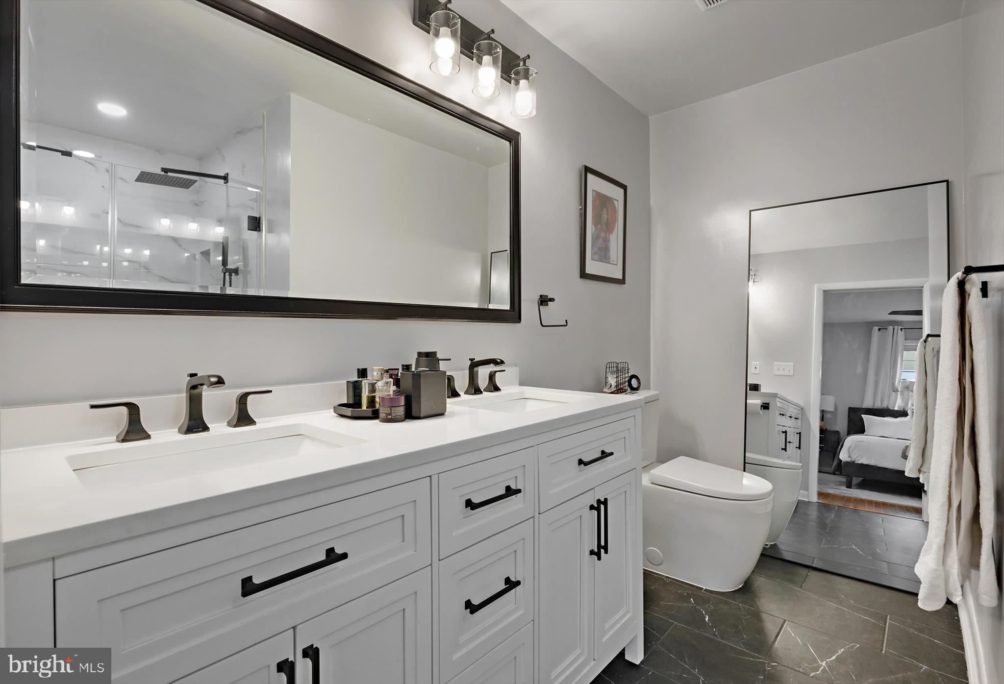 11406 Accolade Terrace Clinton, MD 20735 - Photo 22 of 45 a bathroom with double vanity sinks a mirror and a shower