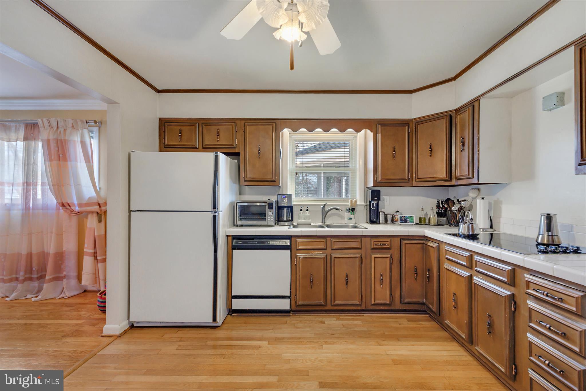 11406 Accolade Terrace Clinton, MD 20735 - Photo 10 of 45 a kitchen with sink a refrigerator and white cabinets
