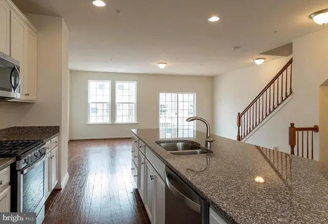 a kitchen with granite countertop a stove a sink and a granite counter tops
