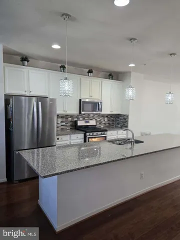 a kitchen with stainless steel appliances granite countertop a sink a refrigerator and a granite counter tops