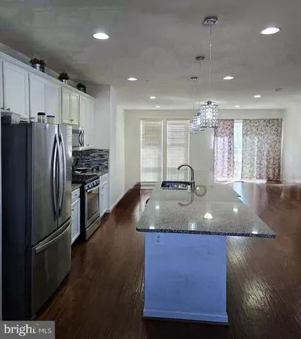 a kitchen with stainless steel appliances granite countertop a sink a stove and a refrigerator