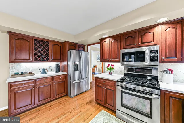 a kitchen with stainless steel appliances wooden cabinets and a stove top oven
