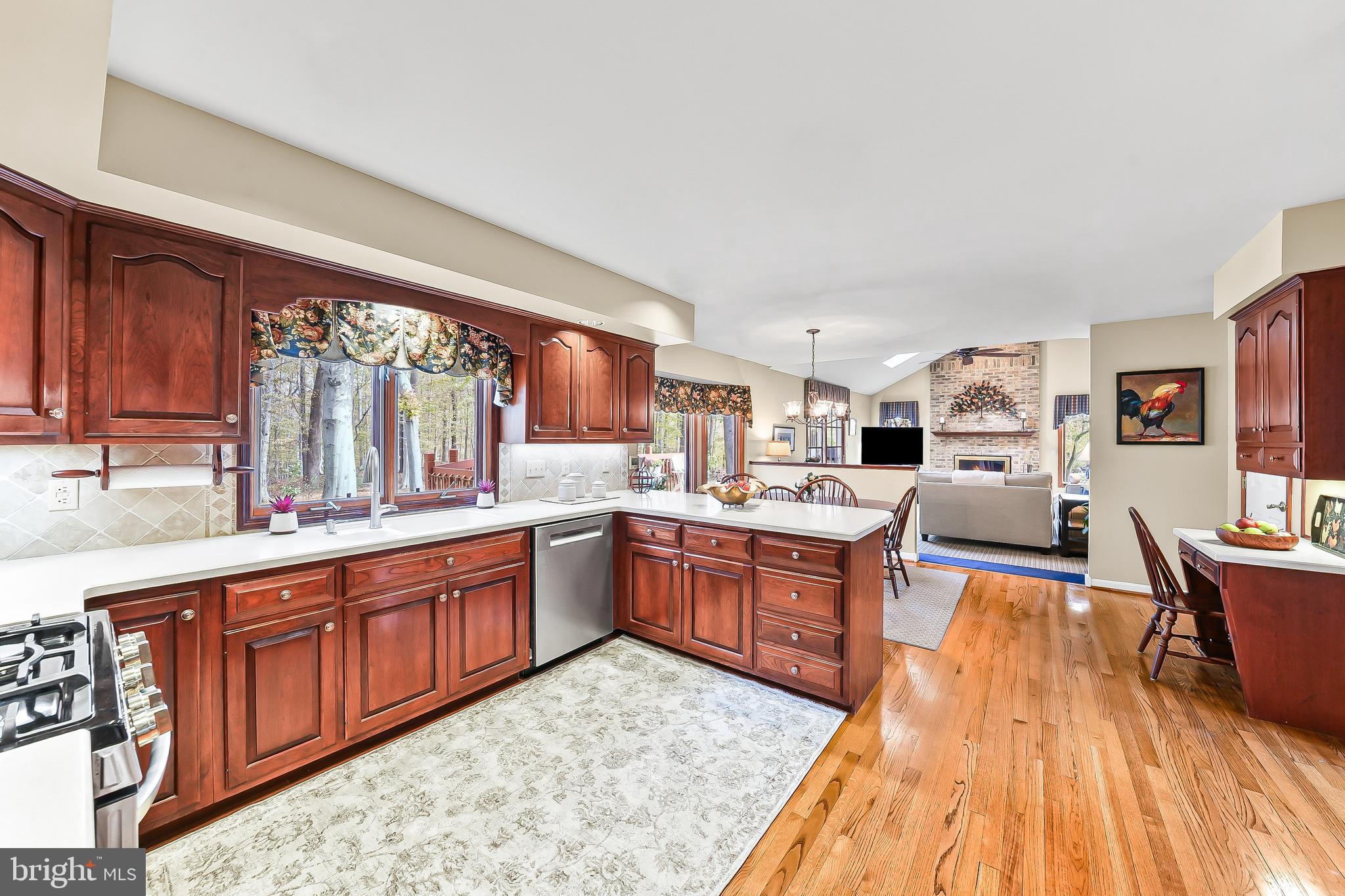 5 Copper Beech Court Landenberg, PA 19350 - Photo 14 of 38 a large kitchen with stainless steel appliances granite countertop a stove top oven a sink dishwasher and wooden cabinets with wooden floor