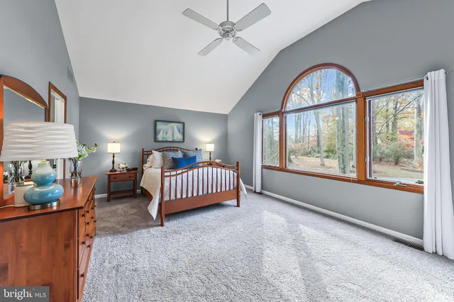 a bedroom with a bed and a large window