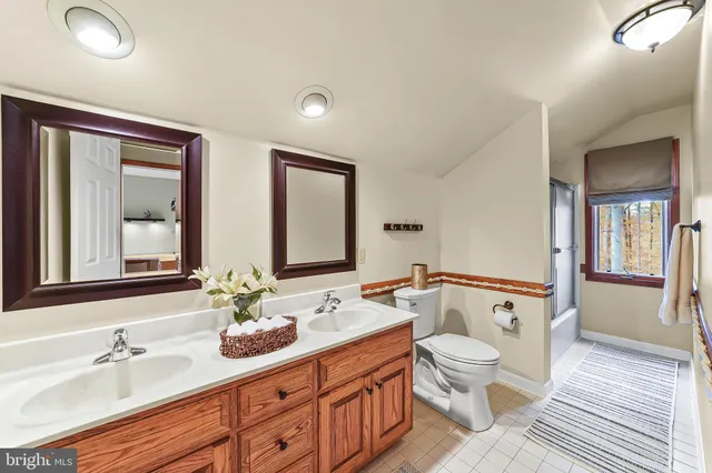 a bathroom with a double vanity sink toilet and shower