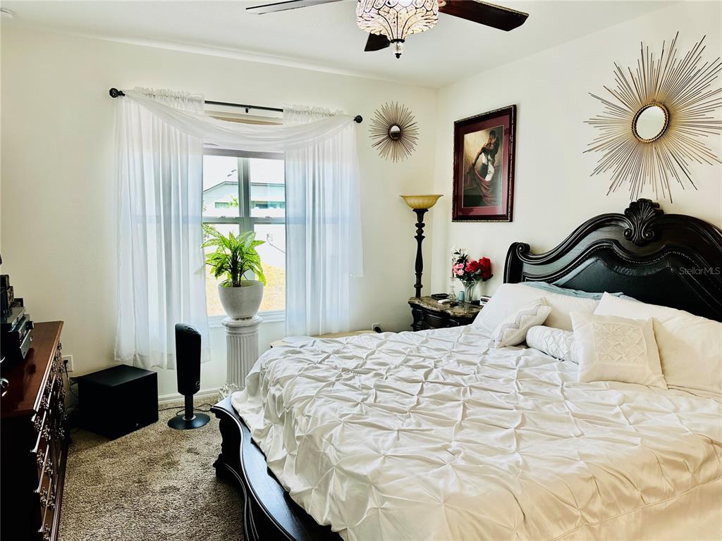 944 Old Windsor Way Spring Hill, FL 34609 - Photo 13 of 31 a bedroom that has a bed and a chandelier