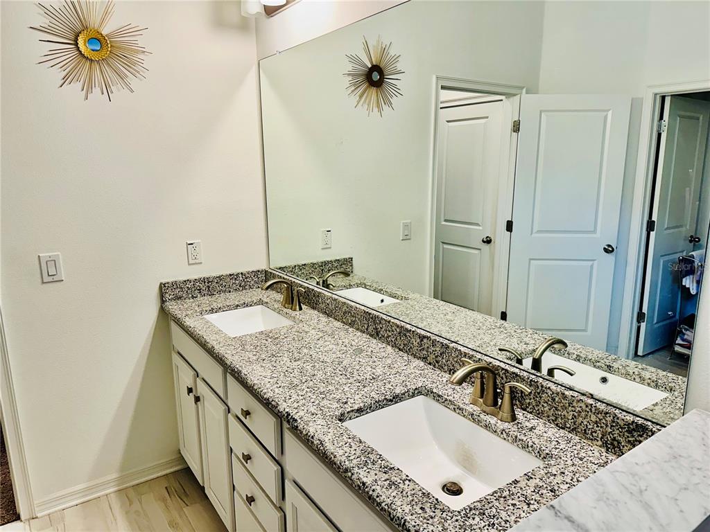 944 Old Windsor Way Spring Hill, FL 34609 - Photo 15 of 31 a bathroom with a granite countertop sink and a mirror