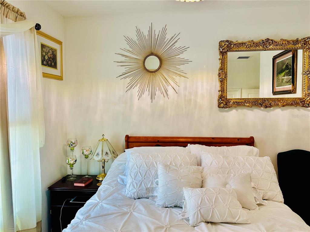944 Old Windsor Way Spring Hill, FL 34609 - Photo 20 of 31 a bedroom with a bed and a chandelier