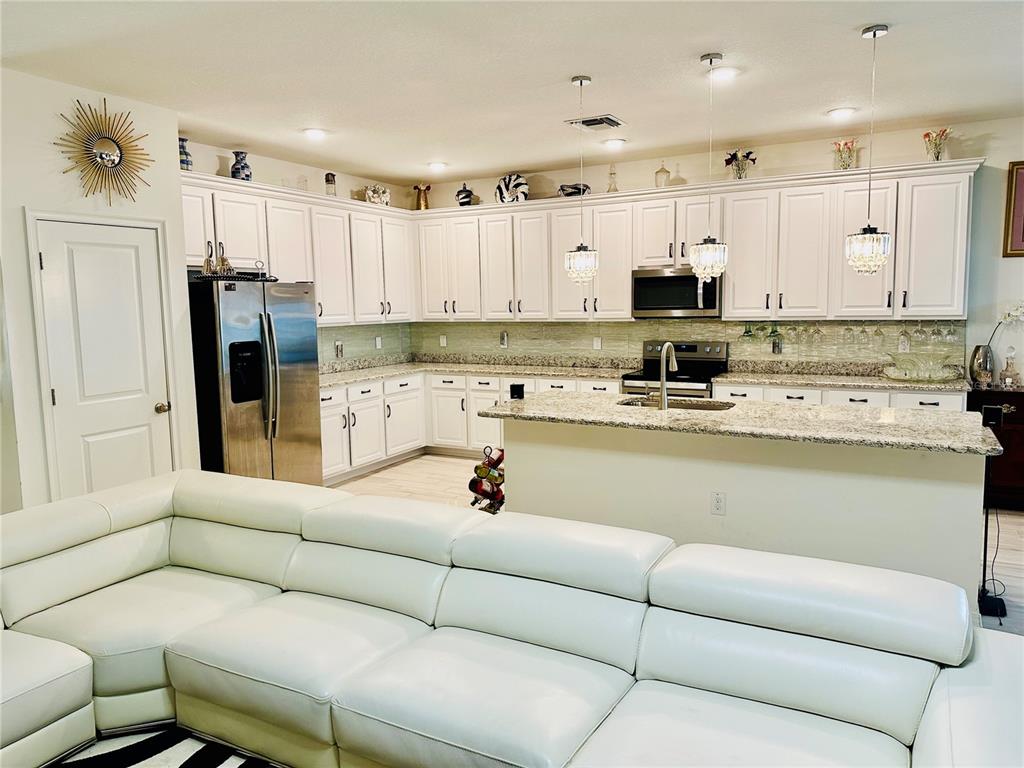 944 Old Windsor Way Spring Hill, FL 34609 - Photo 6 of 31 a living room with furniture and a refrigerator