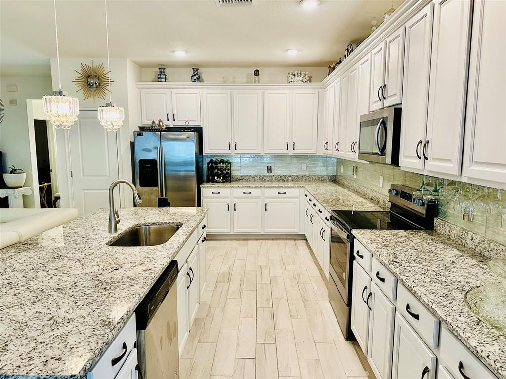 944 Old Windsor Way Spring Hill, FL 34609 - Photo 8 of 31 a kitchen with stainless steel appliances granite countertop a sink stove and refrigerator