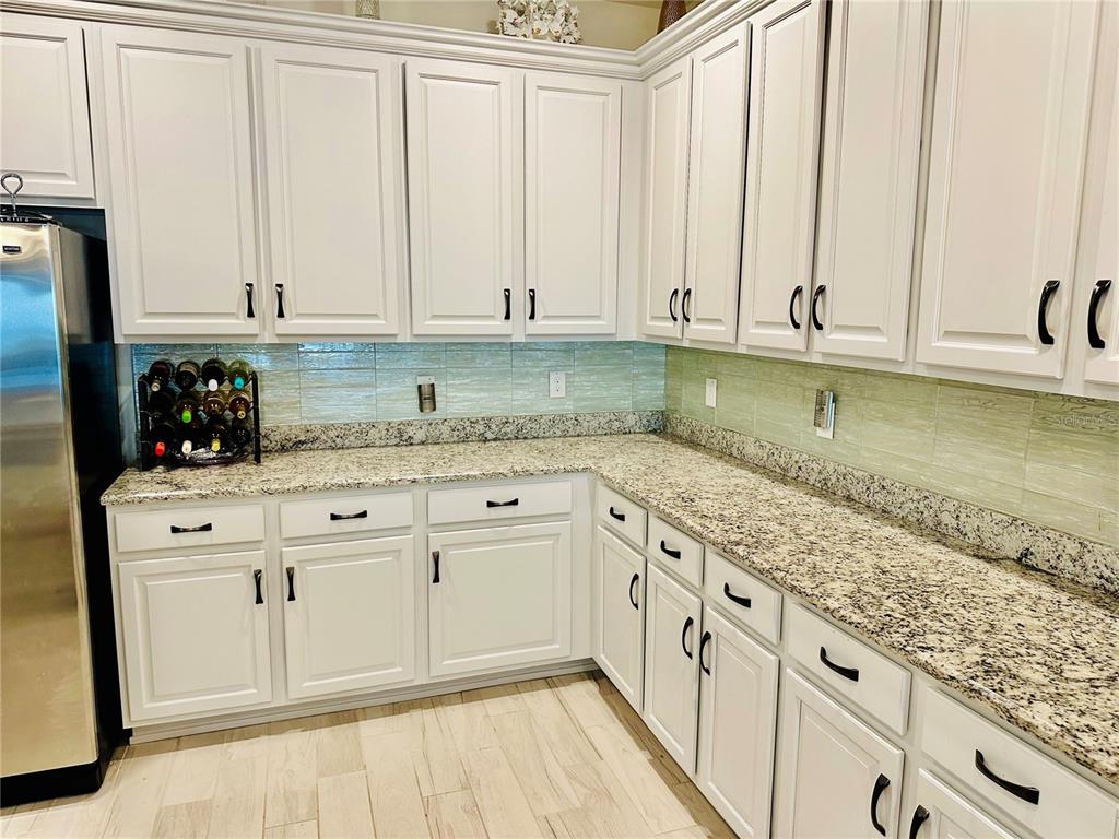 944 Old Windsor Way Spring Hill, FL 34609 - Photo 9 of 31 a kitchen with granite countertop white cabinets and sink