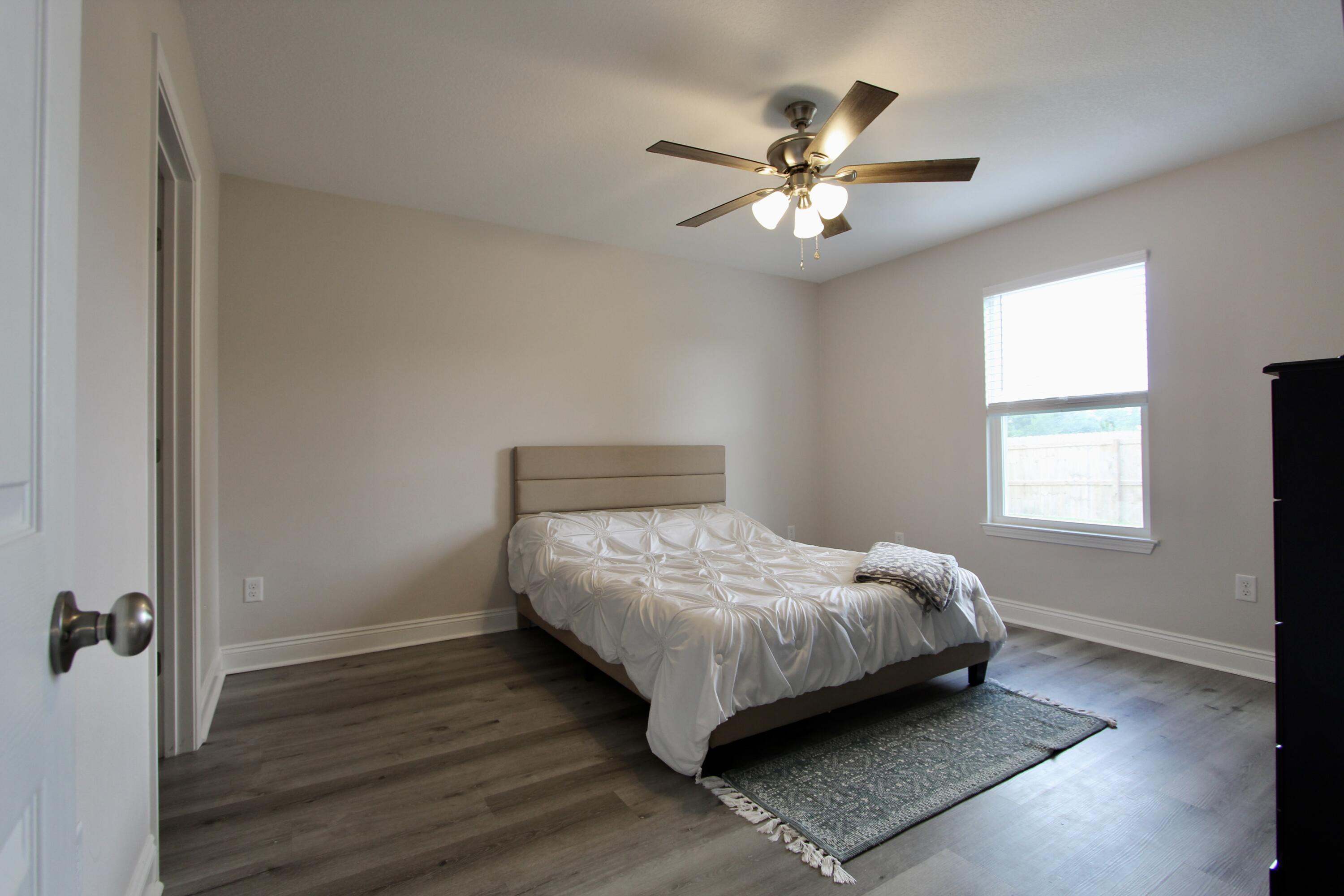 5366 Highview Drive Crestview, FL 32539 - Photo 13 of 19 a bedroom with a bed and a chandelier