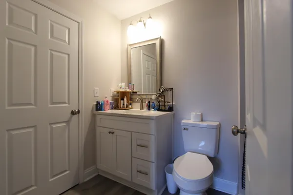 a bathroom with a toilet a sink a vanity and mirror