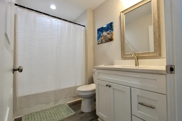 a bathroom with a sink a toilet and shower