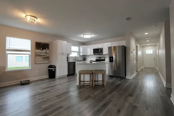 a view of kitchen with refrigerator microwave and wooden floor