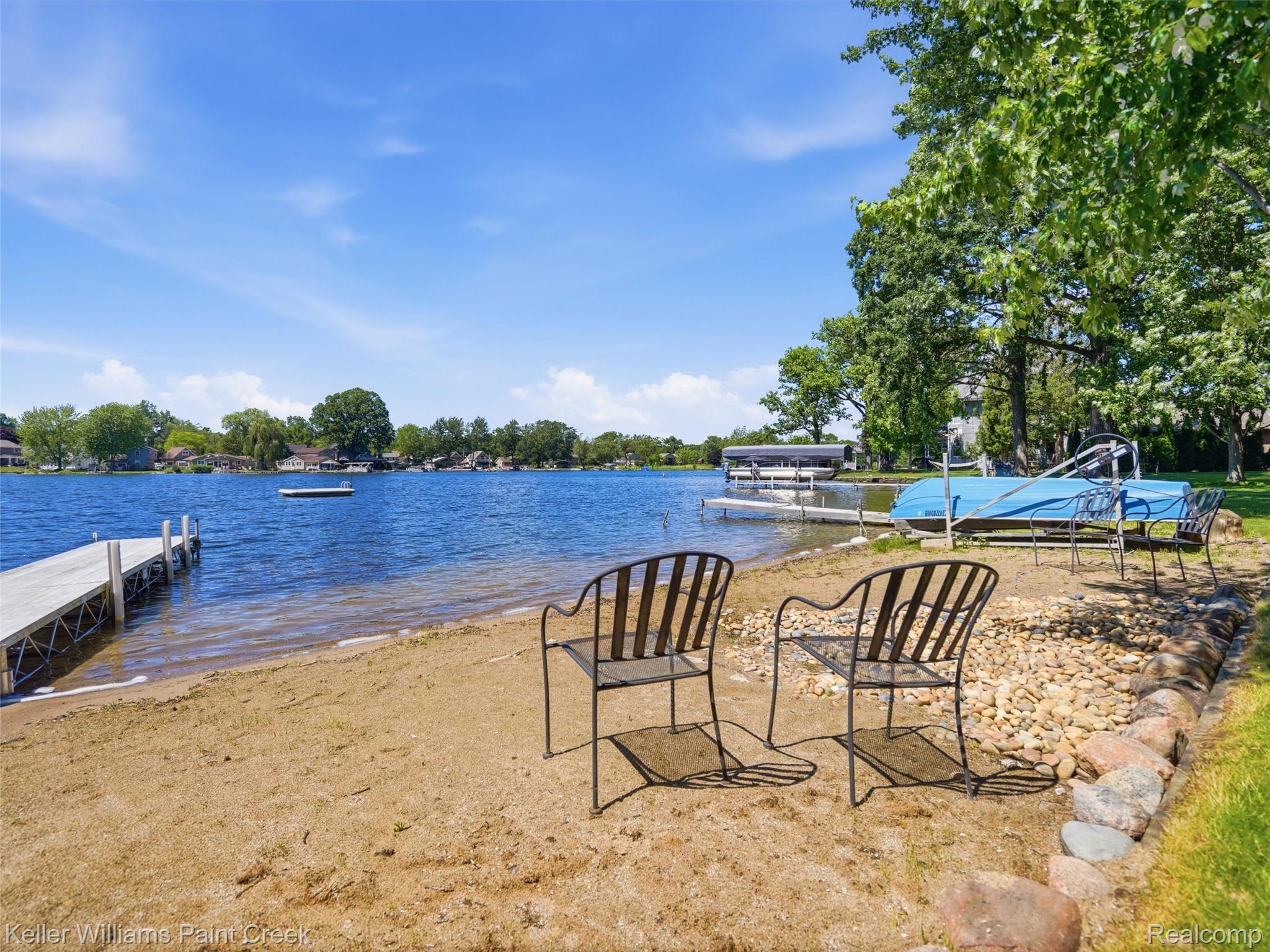 10435 Spring Street Fenton, MI 48430 - Photo 34 of 40 Sandy shoreline featuring a private dock and mature trees