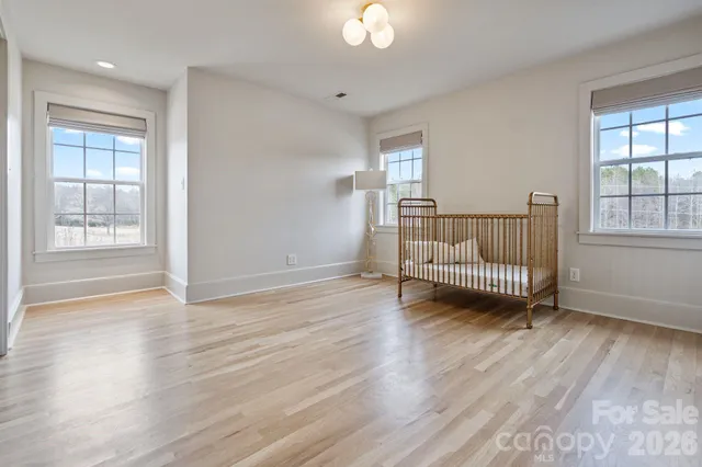 a view of a room with wooden floor fan and windows